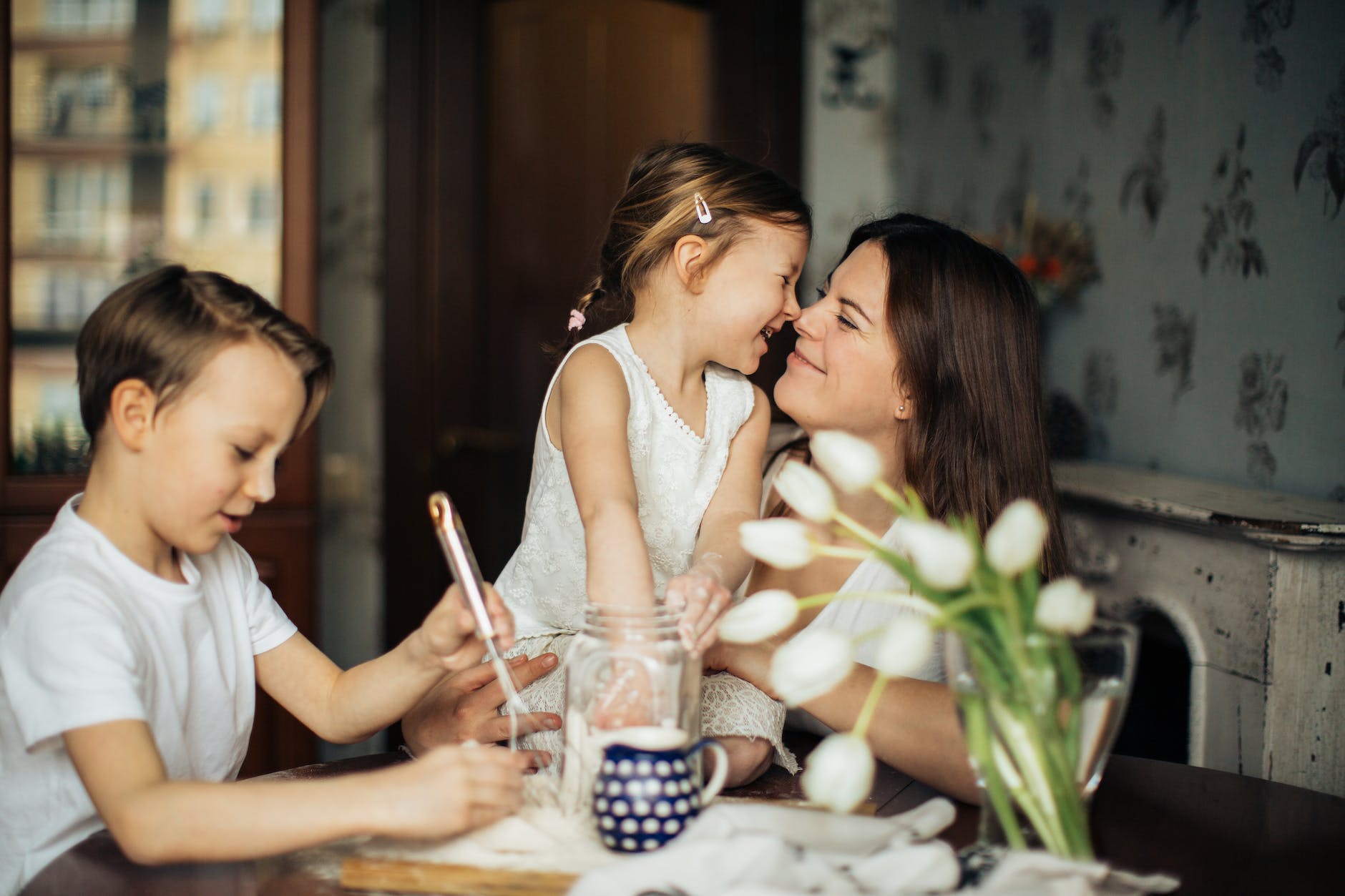 photo of woman playing with her children