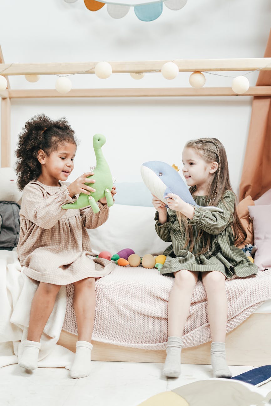 photo of two girls playing with stuffed animals