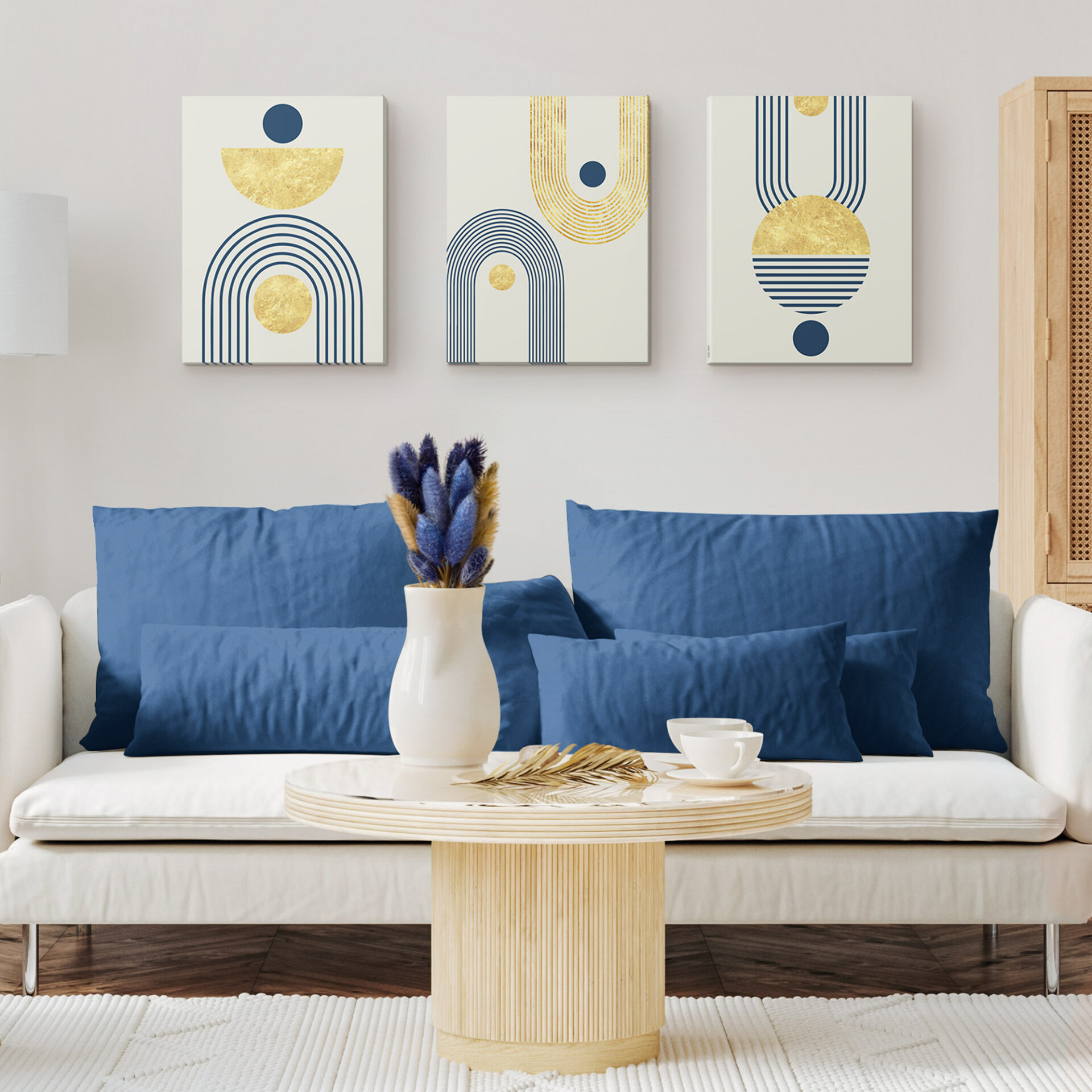 Living room with a wooden headboard and blue pillows, featuring three abstract art canvases with geometric designs in gold and navy blue, including circles, semi-circles, and arches.