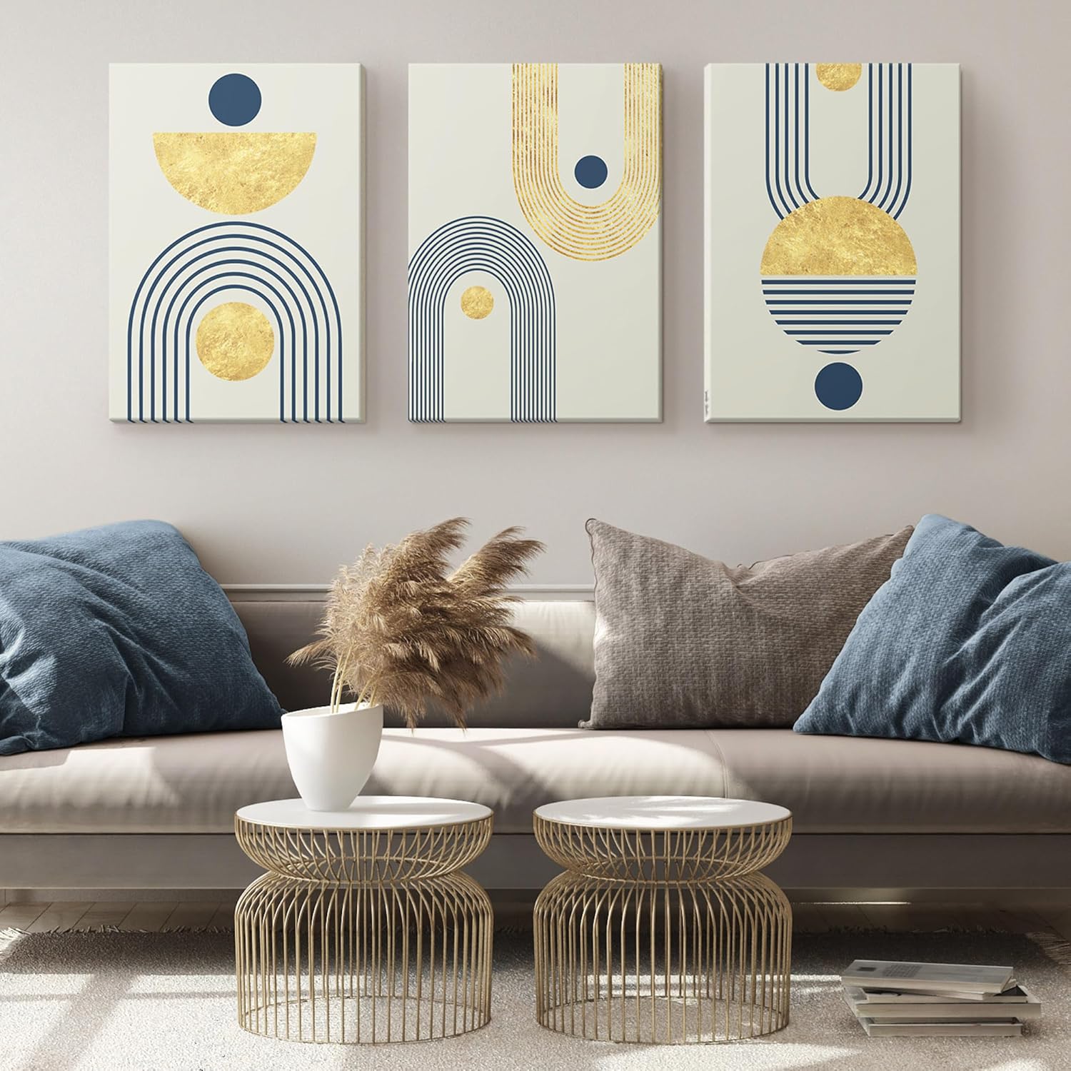 Three abstract art canvases with geometric designs in gold and navy blue, mounted on a wall. The designs feature circles, semi-circles, and arches in a modern, minimalist style.