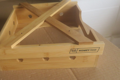 A bamboo paper plate dispenser with the brand name "HOMEY PANDA" displayed on the side, featuring a sturdy X-shaped design on top and hexagonal cutouts along the sides.