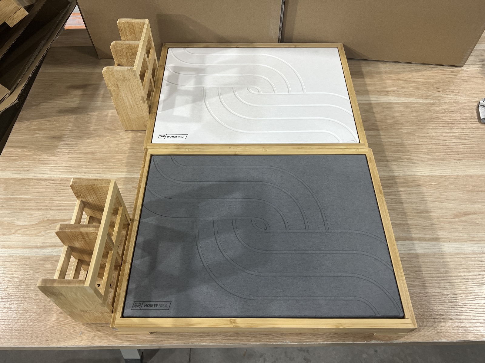 two bamboo drying stone mats with different colored textured surfaces, grey and white, placed side by side on a wooden countertop.