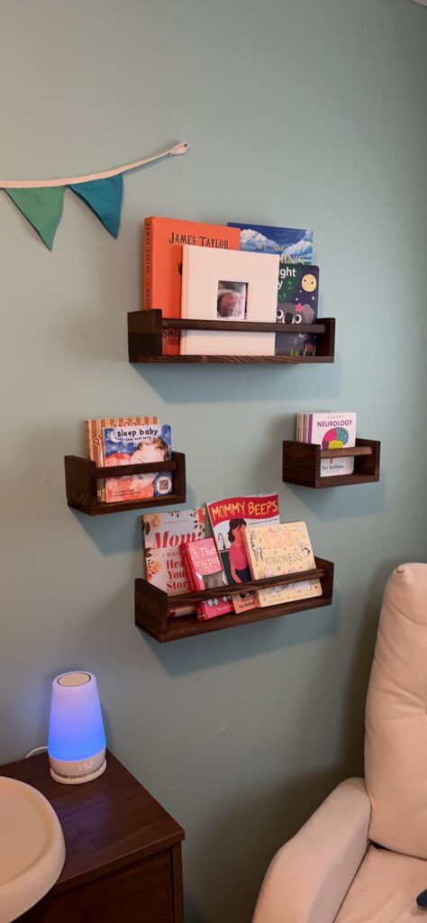 baby book shelf on a grey wall, with toys and books