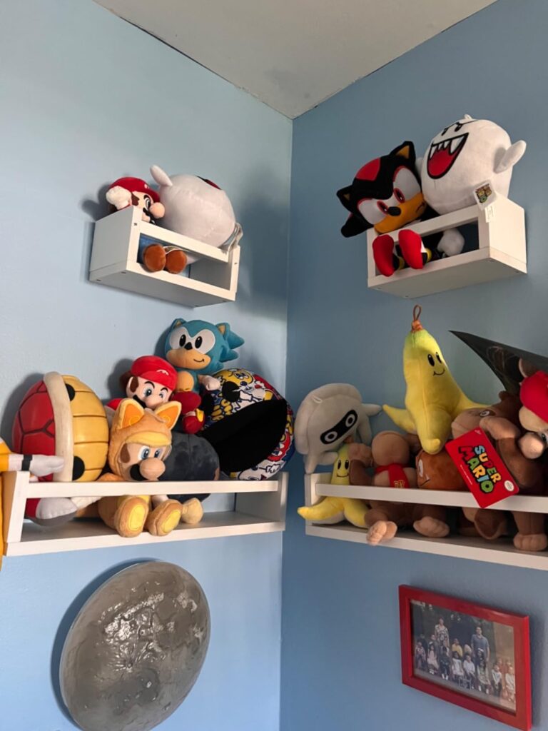 Nursery Shelves for Wall filled with stuffed toys and plush characters, mounted in a corner of a child's room for maximum storage and playful display.