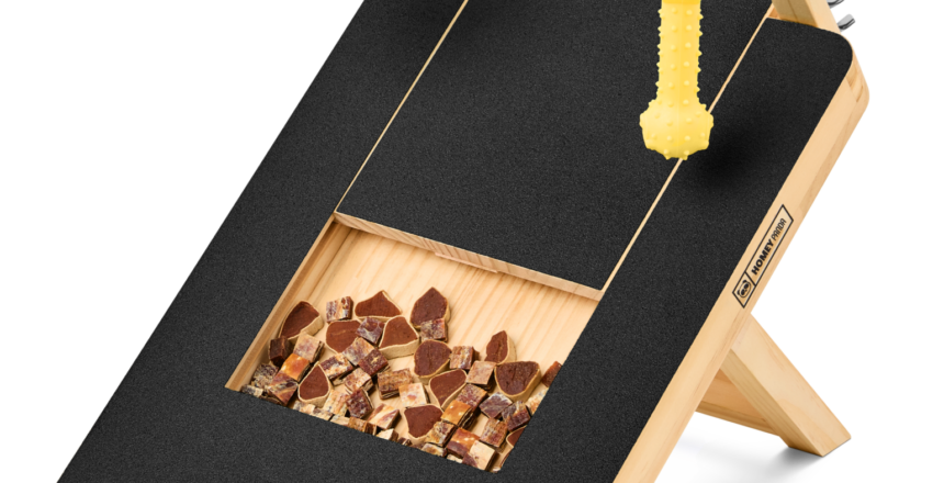 Side view of the dog scratching board showing its sturdy wooden construction, treat compartment, and attached toys for engaging pet training session.